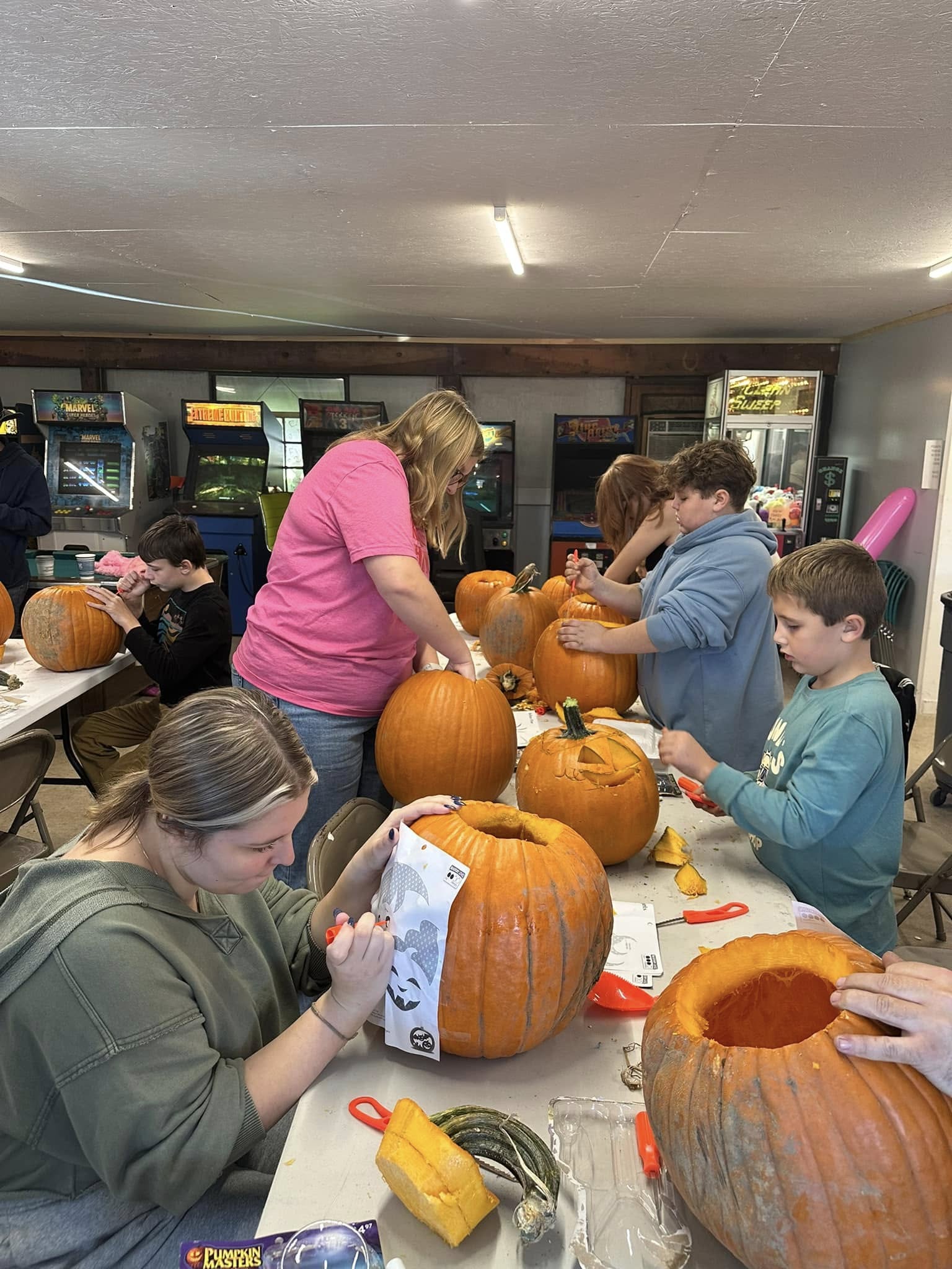 Families carving pumpkins in the campground activity room