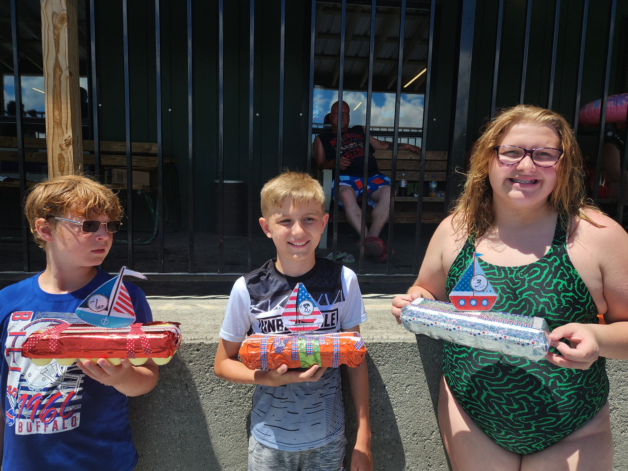 Young campers holding their handmade boats